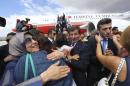 Turkish Consul General of Mosul Yilmaz is welcomed by his relatives as Turkish Prime Minister Davutoglu looks on, as they arrive at Esenboga airport in Ankara