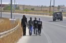 In this Thrusday Aug. 9, 2012 photo illegal immigrants walk along a road in Lavara village, northern Greece, near the borders with Turkey. Greece launched an aggressive campaign this month to try to seal its 200-kilometer (130-mile) northeastern border, as it faces a debilitating financial crisis that has caused a swell in joblessness and a surge in racist attacks against immigrants with dark skin.(AP Photo/Nikolas Giakoumidis)
