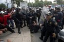 Riot policemen beat a teacher during a protest in Mexico City on September 11, 2013