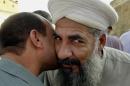 FILE - In this file photo taken Monday, Oct. 18, 2004, Sunni cleric Sheik Khalid al-Jumeili, right, is welcomed by a friend in Fallujah, Iraq, 40 miles (65 kilometers) west of Baghdad, Iraq. Police said gunmen shot dead Sunni cleric Khalid al-Jumeili, an organizer of the western city's Sunni protest camp, in a drive-by shooting. (AP Photo/Bilal Hussein, File)