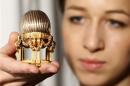 An assistant poses for a photograph with a Faberge egg during a photo-call at antique dealer Wartski, in central London