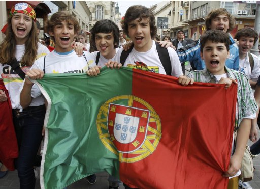 Portuguese fans pose with their national flag as they party in Lviv
