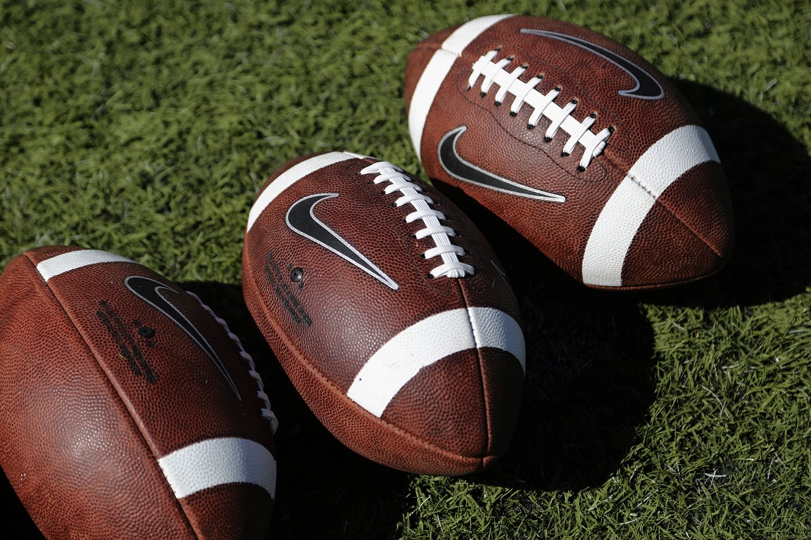 Nike footballs lay on the grass during warm-ups before the start of a college football game between Colorado State and Tulsa Saturday, Oct. 4, 2014, i...