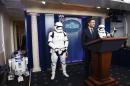 US Press Secretary Josh Earnest speaks to the press in the briefing room at the White House in Washington, DC, on December 18, 2015 with Star Wars characters R2D2 and Storm Troopers