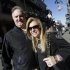In this Friday, Feb. 1, 2013 photo, Sean and Leigh Anne Tuohy, adoptive parents of Baltimore Ravens starting offensive lineman Michael Oher, stand on a street in New Orleans. They were depicted in the move "The Blind Side" and will be attending Sunday's NFL football Super Bowl between the Ravens and the San Francisco 49ers. (AP Photo/Gerald Herbert)
