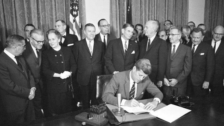 FILE - In this Oct. 31, 1963 file photo, President John F. Kennedy signs a bill authorizing $329 million for mental health programs at the White House in Washington. The Community Mental Health Act, the last legislation that Kennedy signed, aimed to build 1,500 mental health centers so those with mental illnesses could be treated while living at home, rather than being kept in state institutions. It brought positive changes, but was never fully funded. Former U.S. Rep. Patrick Kennedy will host a conference on Oct. 24, 2013 in Boston, to mark the 50th anniversary of the act, and formulate an agenda to continue improving mental health care. (AP Photo/Bill Allen, File)