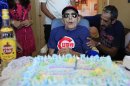 Conrado Marrero, 102, the world's oldest living former major league baseball player, is surrounded by family and friends as he blows out the candle on his birthday cake at his home in Havana, Cuba, Thursday, April 25, 2013. In addition to his longevity, the former Washington Senator has much to celebrate this year. After a long wait, he finally received a $20,000 payout from Major League baseball granted to old-timers who played between 1947 and 1979. The money had been held up since 2011 due to issues surrounding the 51-year-old U.S. embargo on Cuba, which prohibits most bank transfers to the Communist-run island. But the payout finally arrived in two parts, one at the end of last year, and the second a few months ago, according to Marrero's family. (AP Photo/Franklin Reyes)