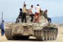 Members of a coalition or fighters who are all opposing the Shiite-Huthi movement drive a tank at the Al-Anad airbase, in Yemen's Lahj governorate, north of Aden, on March 24, 2015