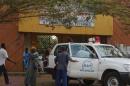 People walk in front of the entrance of the Donka Hospital, where victims of the ebola disease are being treated, in Conakry