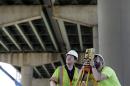 Surveyors work below the Interstate 495 bridge over the Christina River near Wilmington, Del., Tuesday, June 3, 2014, after it was closed due to the discovery of four tilting support columns. The closure created heavier-than-normal traffic conditions for motorists on Interstate 95, a major East Coast artery. The bridge normally carries about 90,000 vehicles a day. (AP Photo/Patrick Semansky)