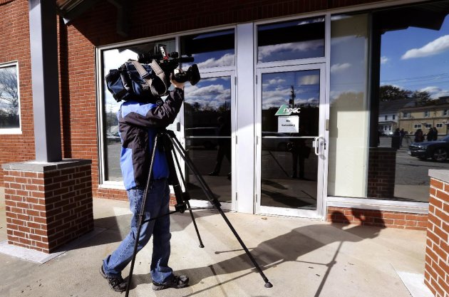 In this Thursday, Nov. 1, 2012, photo, a TV news photographer shoots the facade of the New England Compounding Center, which has since been linked to a recent deadly meningitis outbreak, in Framingham, Mass. According to a congressional investigation released Tuesday, Nov. 13, 2012, federal health inspectors wanted to shut down the New England Compounding Center, until it cleaned up its operations in 2002. Nearly 440 people have been sickened by contaminated steroid shots distributed by New England Compounding Center, and more than 32 deaths have been reported since the outbreak began in September, according to the Centers for Disease Control and Prevention. (AP Photo/Elise Amendola)