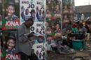 A man reads a newspaper in front of electoral campaign posters in Lagos