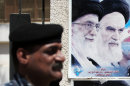 In this Sept. 12, 2012, photo, an Iraqi soldier stands guard next to a poster depicting late Iran's spiritual leaders Ayatollah Khomeini, right, and Ayatollah Khamenei, left, in Basra, 340 miles (547 kilometers) southeast of Baghdad, Iraq. After years of growing influence, a new sign of Iran's presence in Iraq has hit the streets. Thousands of signs, that is, depicting Iran's supreme leader gently smiling to a population once mobilized against the Islamic Republic in eight years of war. (AP Photo/Nabil al-Jurani)
