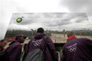 Group of volunteers listen to briefing at corporate sponsor's pavilion that reflects the Olympic Stadium in the Olympic Park, Stratford
