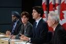 Canada Prime Minister Justin Trudeau answers a question as he is joined by Minister of National Defense Harjit Sajjan, left to right, Minister of International Development and La Francophonie Marie-Claude Bibeau and Minister of Foreign Affairs Stephane Dion during a news conference at the National Press Theatre in Ottawa on Monday, Feb. 8, 2016. (Sean Kilpatrick/The Canadian Press via AP) MANDATORY CREDIT