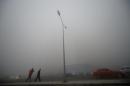 People walk in heavy smog during a polluted day in Jinan