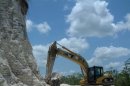 In this image released by Jaime Awe, head of the Belize Institute of Archaeology on Monday May 13, 2013, a backhoe claws away at the sloping sides of the Nohmul complex, one of Belize's largest Mayan pyramids on May 10, 2013 in northern Belize. A construction company has essentially destroyed one of Belize's largest Mayan pyramids with backhoes and bulldozers to extract crushed rock for a road-building project, authorities announced on Monday. (AP Photo/Jaime Awe)