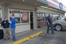 An unidentified customer walks out of the Trex Mart convenience store, right, while manager Chris Nauerz, left, and son of the owner Baron Hartell stand outside, in Dearborn, Mo., Thursday, Nov. 29, 2012. Lottery officials confirmed Thursday that one of two winning Powerball tickets sold before Wednesday's drawing was bought at a Trex Mart convenience store in Dearborn. (AP Photo/Orlin Wagner)