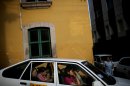 FILE - In this Sept. 24, 2009 file photo, passengers ride in a taxi in downtown Tegucigalpa, Honduras. Taxi drivers are known to pay extortionists more than $500 a year to park on public property. During Christmas, the cabbies dish out another $500 each in holiday 