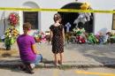 Kate Daby and her 6-year-old daughter Adeline looks at flowers and notes placed on the sidewalk in front of the Emanuel AME Church on Friday, June 19, 2015 in Charleston, S.C. Dylann Storm Roof, 21, is accused of killing nine people during a Wednesday night Bible study at the church. ( Curtis Compton/Atlanta Journal-Constitution via AP) MARIETTA DAILY OUT; GWINNETT DAILY POST OUT; LOCAL TELEVISION OUT; WXIA-TV OUT; WGCL-TV OUT