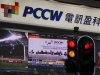 A screen broadcasts a live news feed of an extraordinary general meeting of PCCW outside a PCCW outlet in Hong Kong