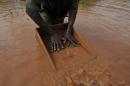 A man sifts through pebbles searching for diamonds in the village of Bobi, north western Ivory Coast, on November 18, 2009