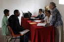 In this Tuesday, July 10, 2012, Rogelio Hernandez Sanchez, 34, second from left, and his son, Rogelio Hernandez Medina, 7, left, listen to Ellen Calmus, right, a coordinator of the "Proyecto El Rincon" or "The Corner Project", a local non-profit organization for migrant families, as he tries to get his son's U.S. birth certificate stamped by Mexican authorities in Malinalco, Mexico. Because of the Byzantine rules of Mexican and U.S. bureaucracies, tens of thousands of U.S. born children of Mexican migrant parents now find themselves without access to basic services in Mexico - unable to officially register in school or sign up for health care at public hospitals and clinics that give free check-ups and medicines.(AP Photo/Dario Lopez-Mills)