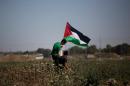 A Palestinian protestor holds his national flag during a demonstration in solidarity with prisoners held in Israeli jails, near the Nahal Oz border crossing with Israel, east of Gaza City, on April 18, 2014