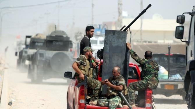 Iraqi Shiite militia fighters ride in a truck after pushing back Islamic State group militants on September 3, 2014, on the road between Amerli and Tikrit