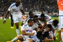 Marseille's players celebrate after Marseille's Belgian forward Michy Batshuayi, second left bottom, scored against Bordeaux, during their League One soccer match, at the Velodrome Stadium, in Marseille, southern France, Sunday, Nov. 23, 2014. (AP Photo/Claude Paris)