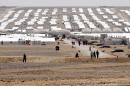 Syrian refugees, who fled the deadly conflict in their country, walk at Azraq refugee camp on April 28, 2015 in Jordan