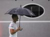 Mercedes Formula One driver Schumacher of Germany walks through the paddock as it rains ahead of the first practice session of the Singapore F1 Grand Prix
