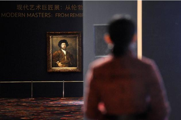 Una mujer observa una obra del holandés Rembrandt en Pekín el 28 de noviembre de 2013. Obras de Rembrandt, Picasso, Renoir o Rodin se subastarán en Pekín, mostrando el creciente apetito chino por el a