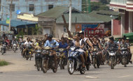 Hundreds of Buddhists on motorcycles armed with sticks patrol in the streets of in Lashio, northern Shan State, Myanmar, Wednesday, May 29, 2013. Sectarian violence spread to a new region of Myanmar, with a mob

 burning shops in
 the northeastern town after unconfirmed rumors spread that a Muslim man had set fire to a Buddhist woman. (AP Photo/Gemunu Amarasinghe)