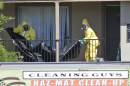 Hazardous material cleaners prepare to hang black plastic outside the apartment in Dallas, Friday, Oct. 3, 2014, where Thomas Eric Duncan, the Ebola patient who traveled from Liberia to Dallas stayed last week. The family living there has been confined under armed guard while being monitored by health officials. (AP Photo/LM Otero)