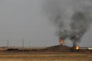 Smoke rises from an oil field in Al-Rmelan, Qamshli province
