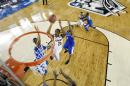 Connecticut guard Lasan Kromah (20) shoots between defenders Kentucky forward Marcus Lee (00) and guard Aaron Harrison (2) during the first half of the NCAA Final Four tournament college basketball championship game Monday, April 7, 2014, in Arlington, Texas. (AP Photo/Chris Steppig, pool)