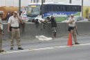 The body of a boy lies covered on a road as police officers control traffic at the Brasil Avenue during an operation by Rio de Janeiro's Social Action Secretariat to bring crack addicts to shelters for rehabilitation, in Rio de Janeiro