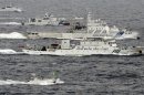 An aerial photo shows a Chinese marine surveillance ship Haijian No. 66 cruising next to Japan Coast Guard patrol ships in the East China Sea