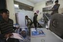 Labourers print posters of presidential election candidates at a printing press in Kabul