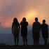 People watch a giant smoke plume rising from the Waldo Canyon Fire during sunset, west of Colorado Springs