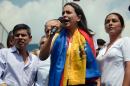 Dismissed opposition deputy Maria Corina Machado (C), Peruvian deputies Cecilia Chacon (R) and Luis Galarreta (L) take part in a protest against the Venezuelan government in Caracas on March 26, 2014