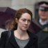 Rebekah Brooks, the former chief of News Corp.'s British newspapers is watched by a police officer as she leaves after attending a hearing in a corruption case at the Old Bailey court in the City of London, Friday, March 8, 2013.  Brooks appeared in court Friday to face charges over alleged conspiracy to bribe a public official to obtain information.  (AP Photo/Matt Dunham)