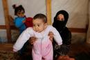 Syrian refugee Asheqa holds her unregistered baby daughter Nour inside a tent at a refugee camp in LebanonÕs Bekaa valley