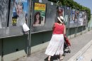 A woman looks at posters for the French general election, in Nice, southeastern France, Saturday, June 9, 2012, on the eve of the first round of the French general election. The second round will take place on June 17t to elect the 14th National Assembly of the 5th Republic. (AP Photo/Lionel Cironneau)