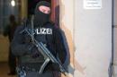 A member of a police task force stands in front of an apartment building where raids took place against suspected jihadists on January 16, 2015 in Berlin