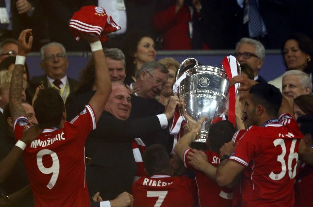Bayern Munich players pass trophy to Bayern Munich President Hoeness as they celebrate after winning Champions League final soccer match against Borussia Dortmund in London