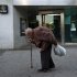 An elderly man walks past a branch of Spain's lender bank Bankia in Madrid
