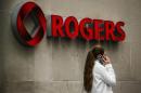 A woman speaks on her phone in front of a Rogers Communications Inc sign before the company's AGM in Toronto