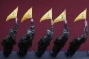 Hezbollah fighters hold flags during the funeral procession of commander Mustafa Badreddine during his funeral procession in a southern suburb of Beirut, Lebanon, Friday, May 13, 2016. Badreddine died in an explosion in Damascus, a death that is a major blow to the Shiite group, which has played a significant role in the conflict next door. (AP Photo/Hassan Ammar)